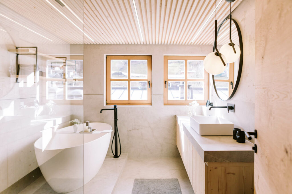 Tischlerei Trixl - Badezimmer mit weißer Badewanne und Holzmöbeln, Bad T