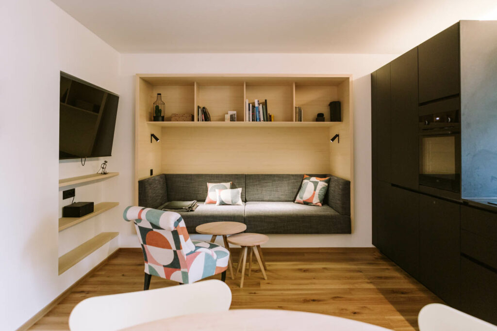Tischlerei Trixl - Zimmer mit Sofa und Holzboden, Studio F
